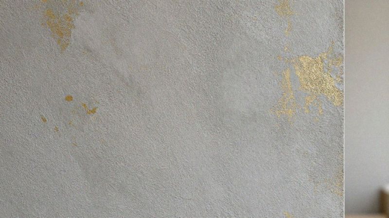 Jakie cechy ma tapeta imitująca beton ze złotymi akcentami?
